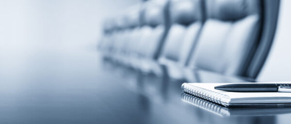 Closeup of notepad kept on table in empty conference room