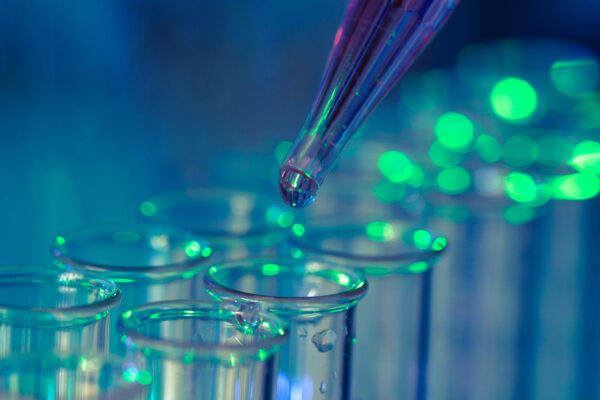 Dropper in a biotech lab putting fluid in tubes