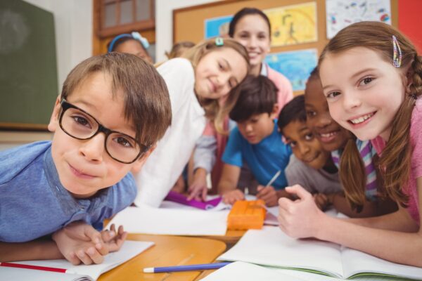 Teacher and pupils working at desk together