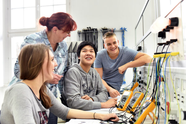 Four people working in a white room with technical tools