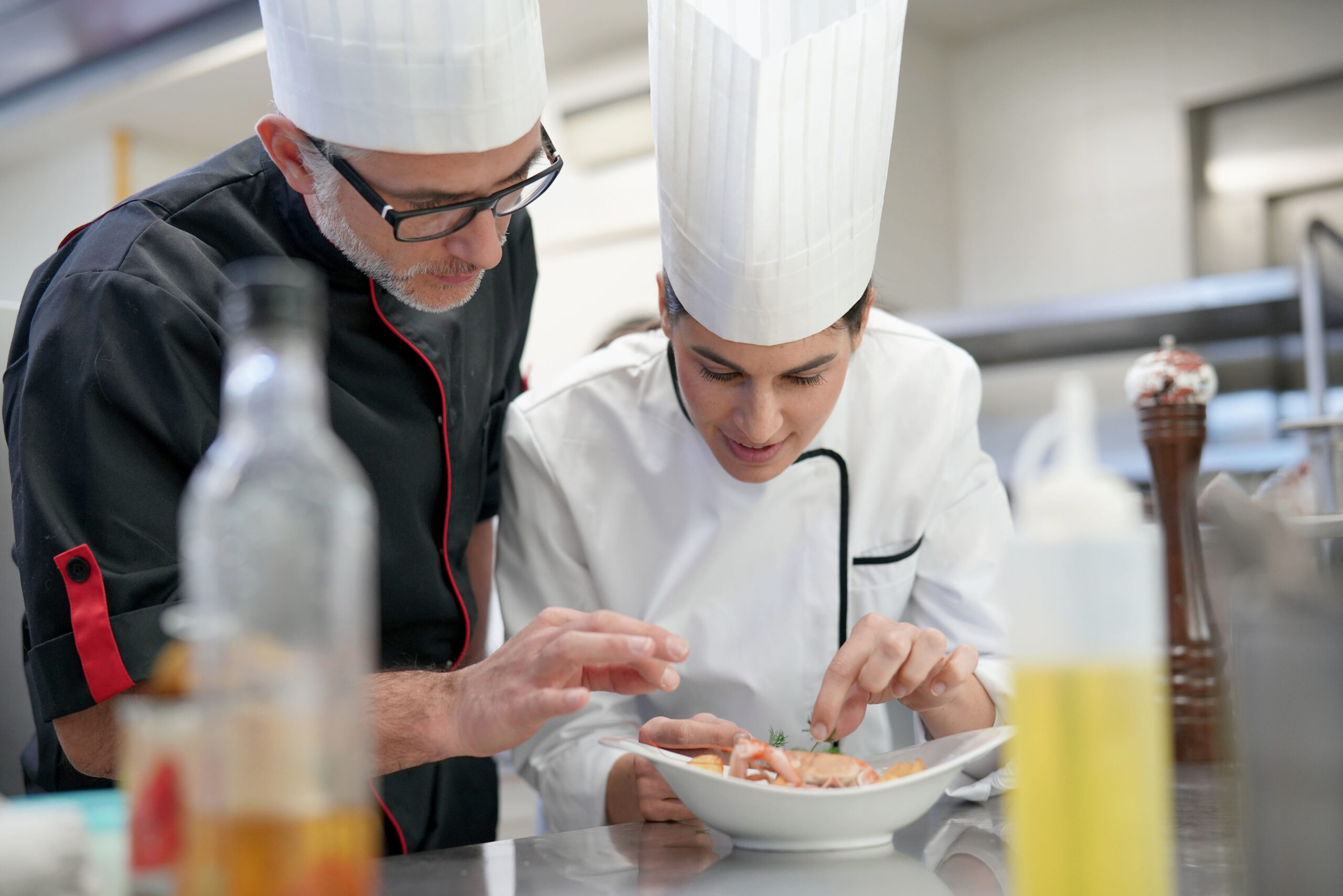 Culinary training with a head chef working on plate presentation