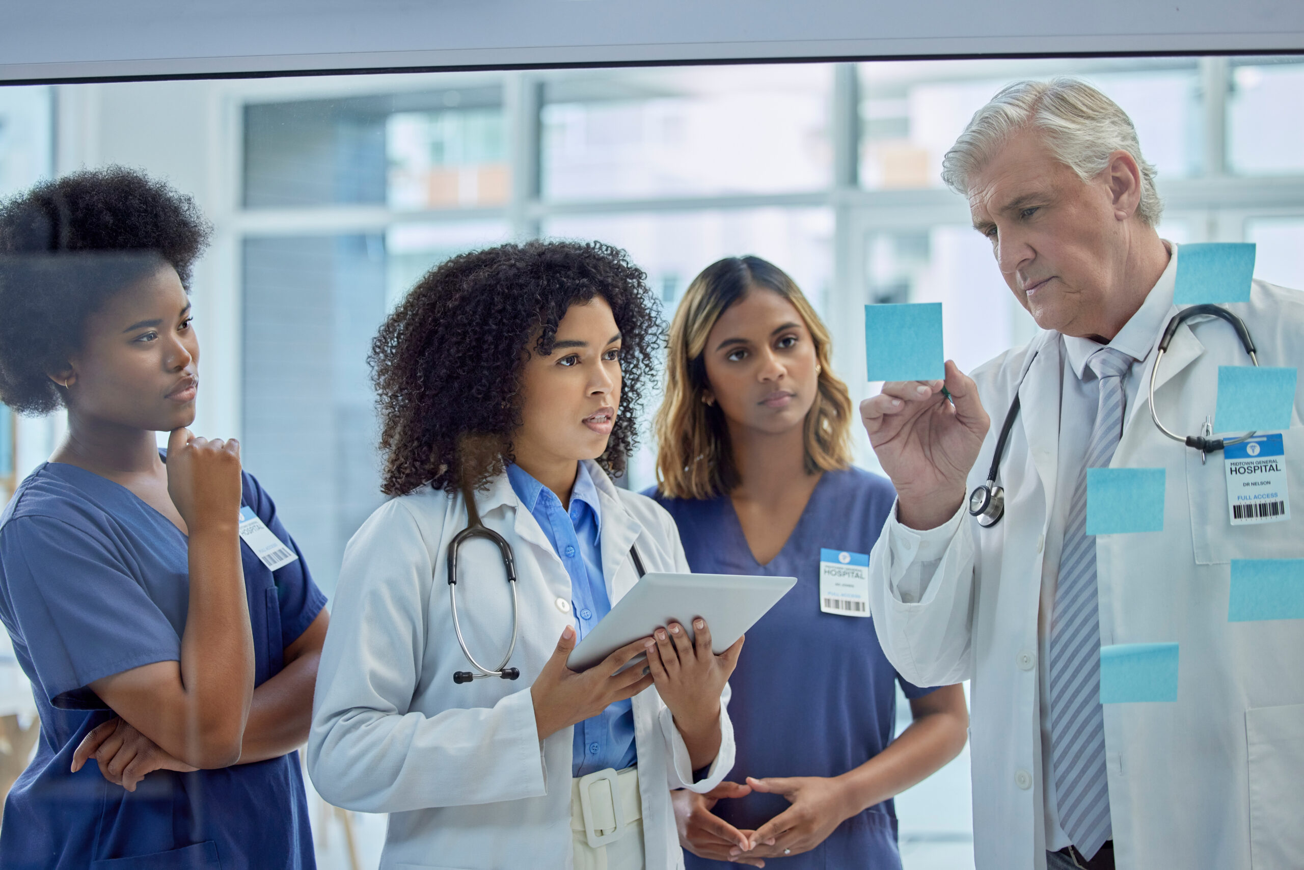 Healthcare workers training with a doctor in the medical field, reviewing notes