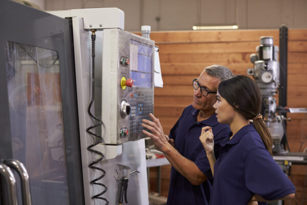 Engineer Training Female Apprentice On CNC Machine