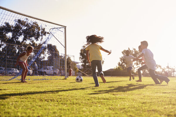 Kids playing soccer in the sunshine