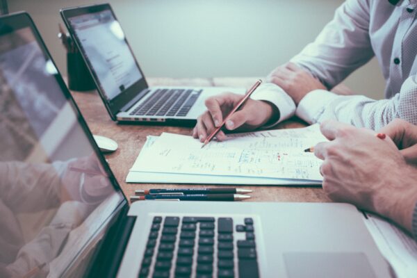 Two laptops with paperwork in the middle