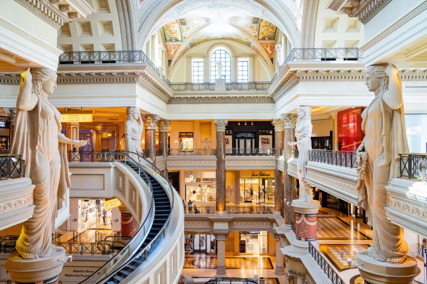 Forum Shops – A grand shopping mall with Roman-inspired statues, spiral escalators, and ornate classical architecture.